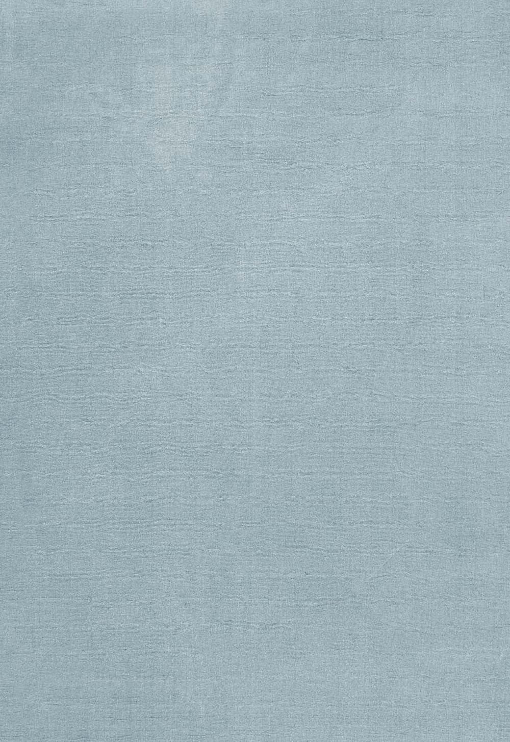 Solid wool blue clair rug photographed in a styled interior