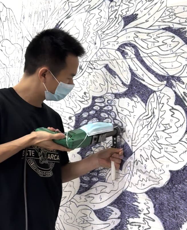 Người thợ đang dệt thảm theo bản thiết kế